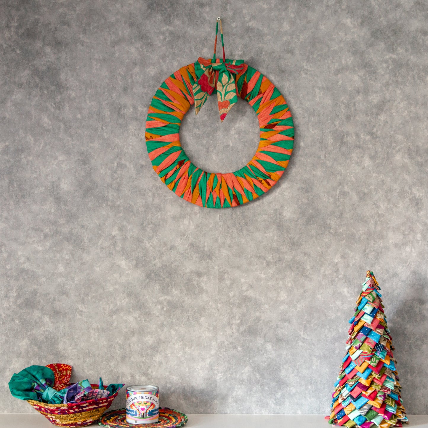 Colorful wreath and Christmas tree decoration on a gray wall