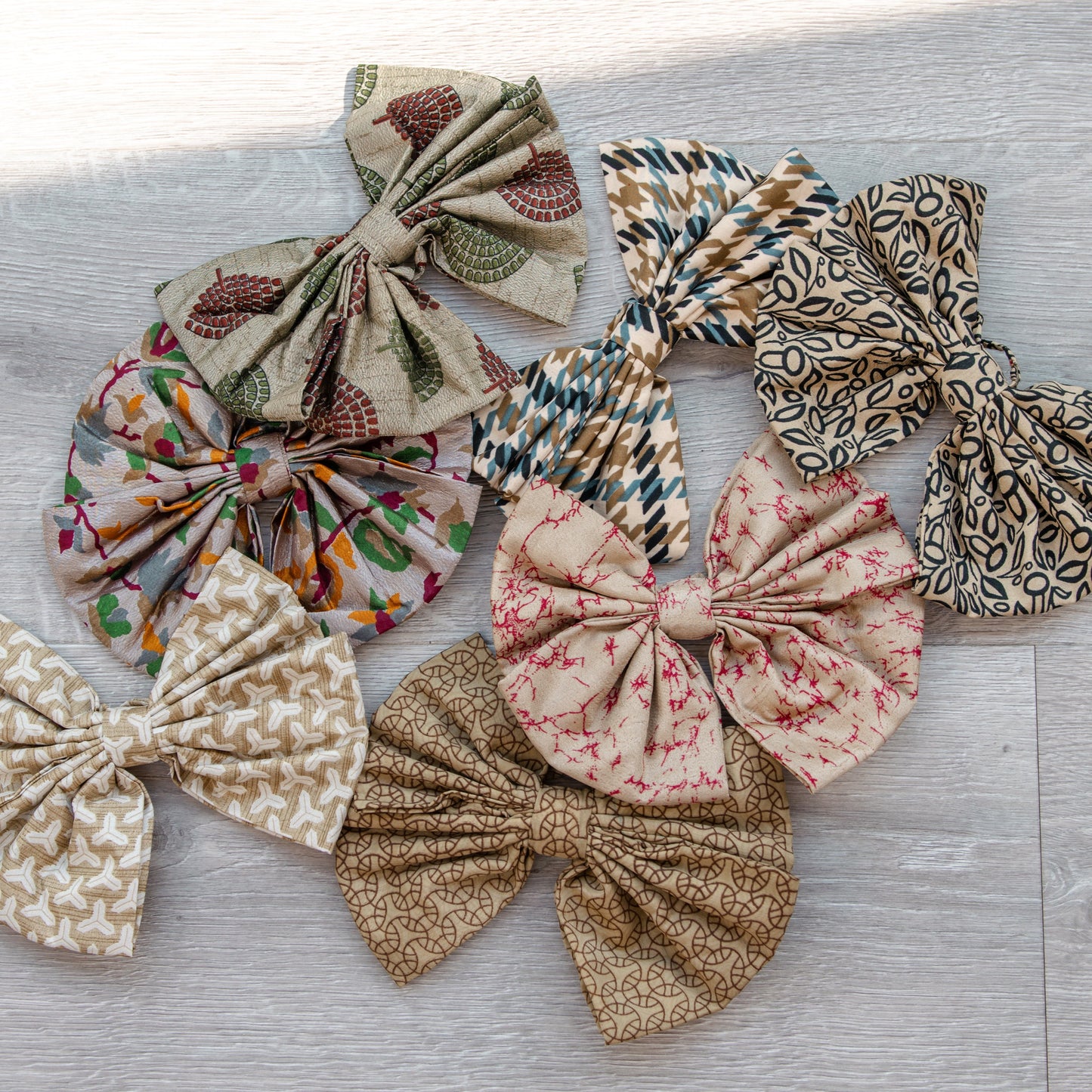 Collection of variously patterned fabric bows on a wooden surface