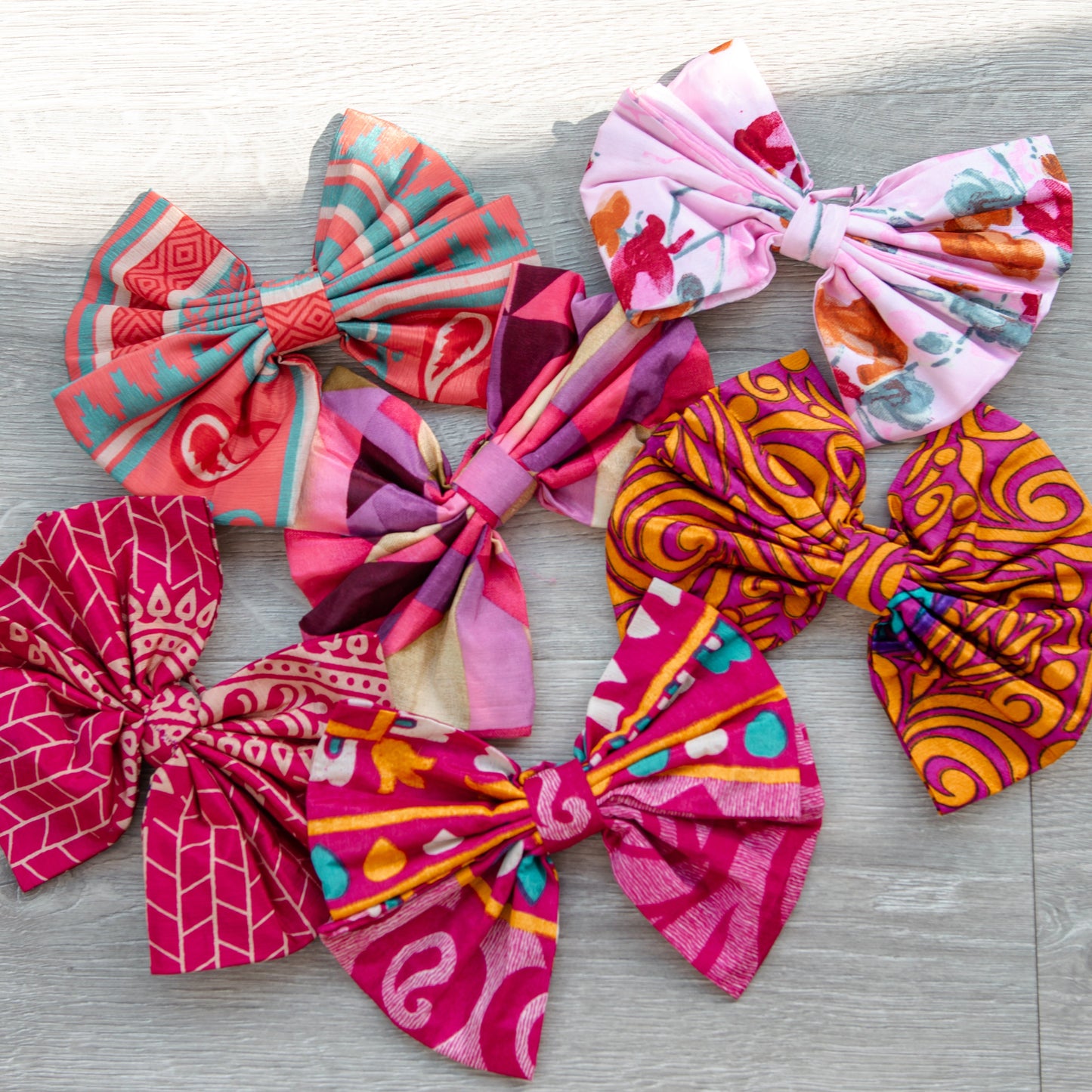 Colorful fabric pink bows on a wooden surface