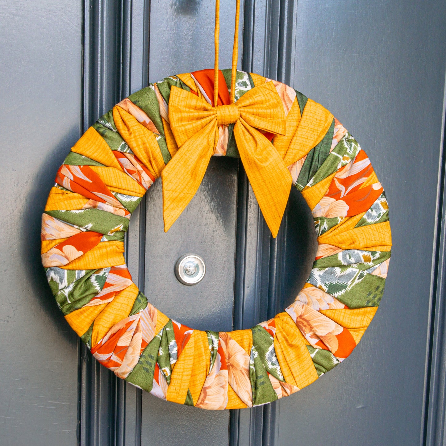 Colorful wreath with a yellow bow on a gray door