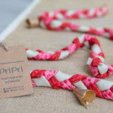 Braided garland with pink, white, and beige pattern on a textured surface with a 'PriPri' tag.