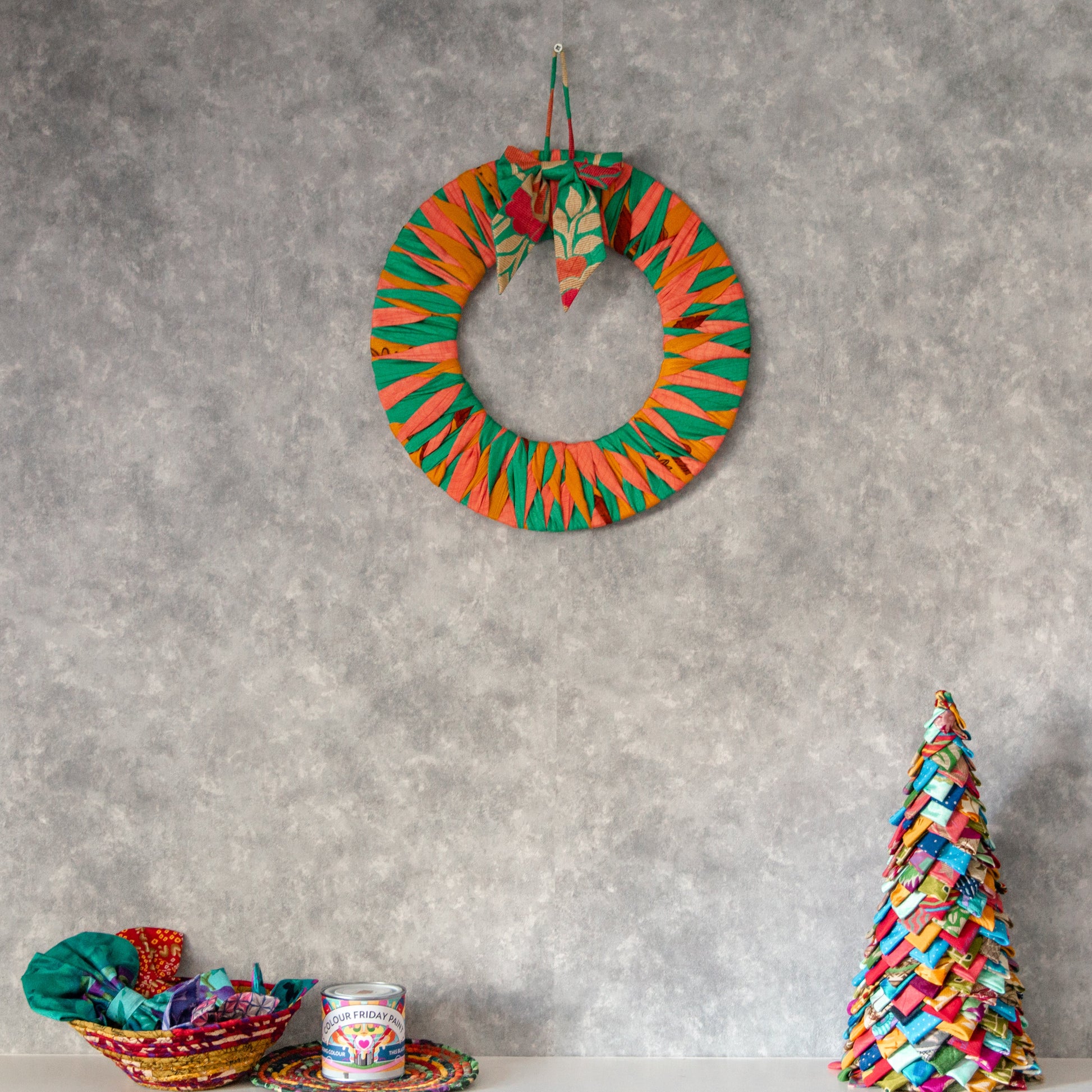 Colorful wreath and Christmas tree decoration on a gray wall