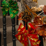 Decorative wreath with colorful bows on a staircase railing.