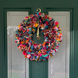 Colorful wreath on a green door with a gold doorknob