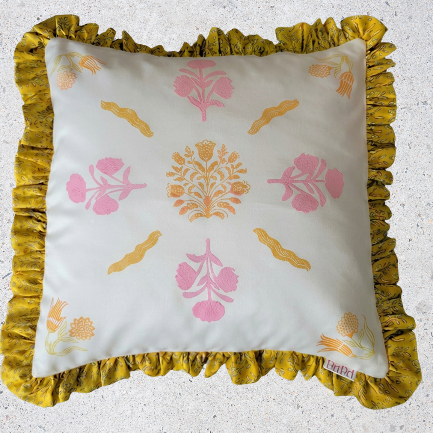 Decorative pillow with floral patterns and yellow ruffled edge on a light background