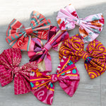 Colorful fabric pink bows on a wooden surface