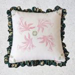Decorative pillow with floral pattern and ruffled edge on a light background