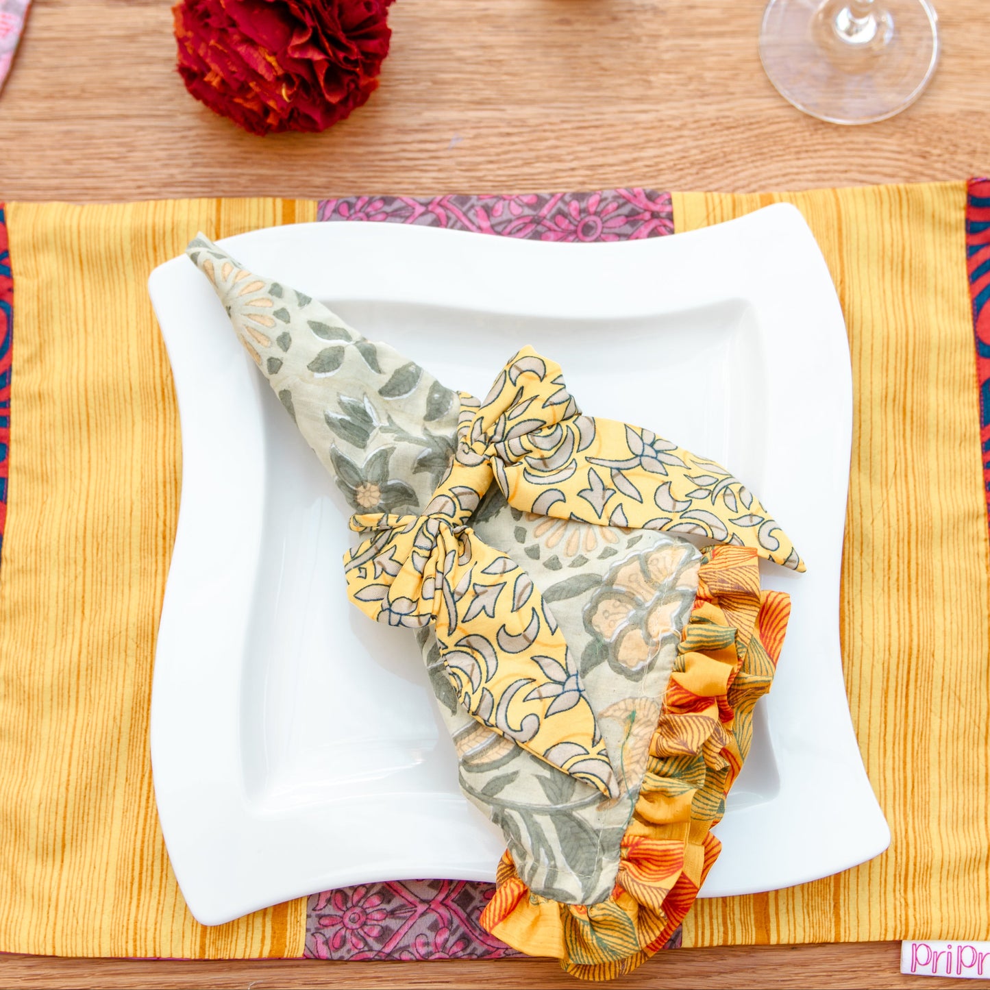 Colorful table setting with a decorative napkin on a wooden table.
