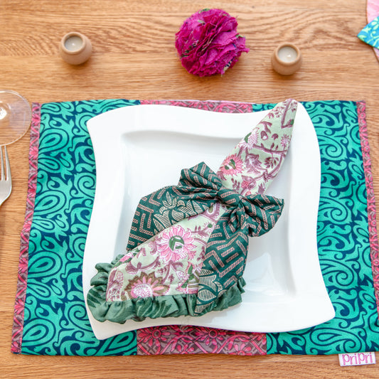 Decorative table setting with a patterned napkin and placemat on a wooden table.