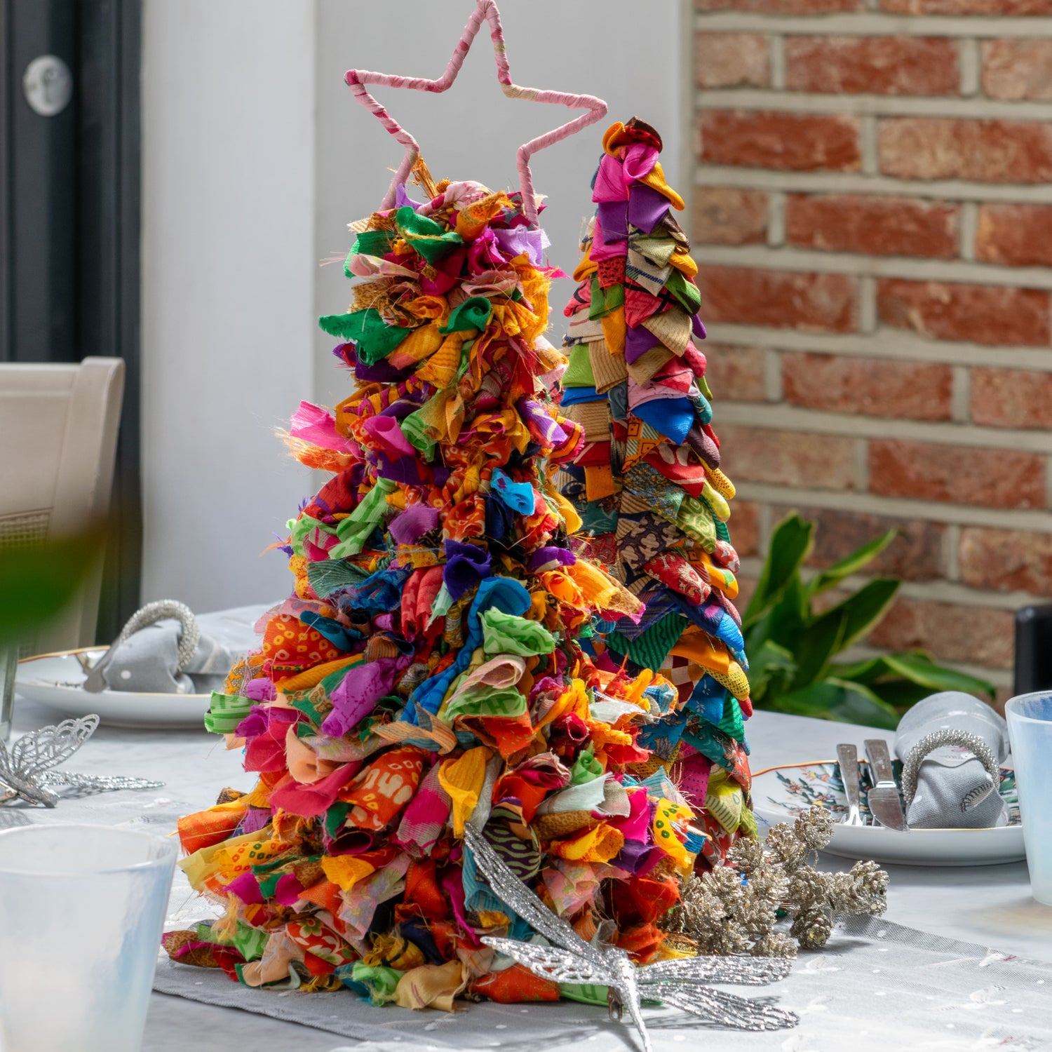 Colorful fabric Christmas tree on a table with a brick wall background