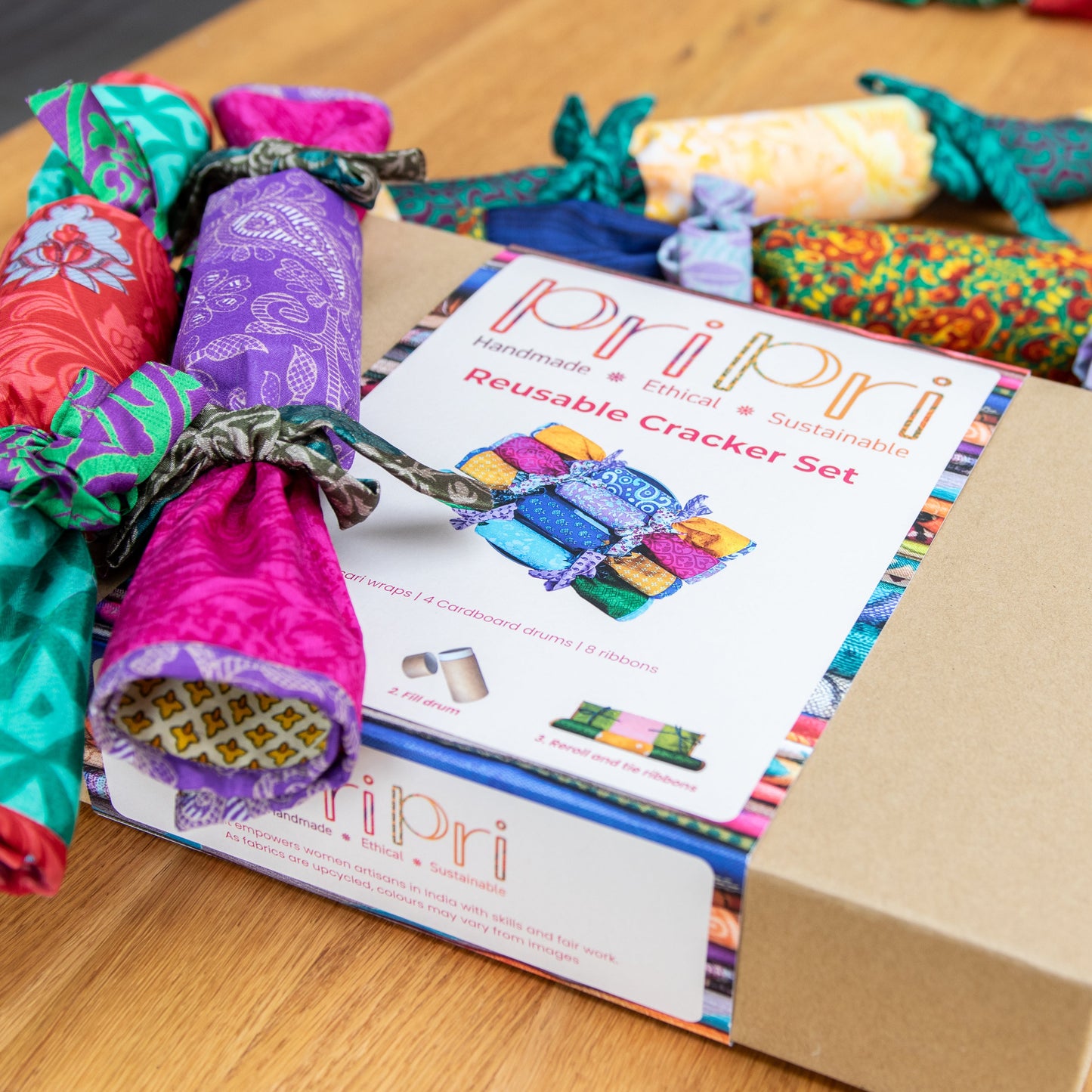 Pri Pri reusable cracker set with colourful cracker packages on a wooden surface